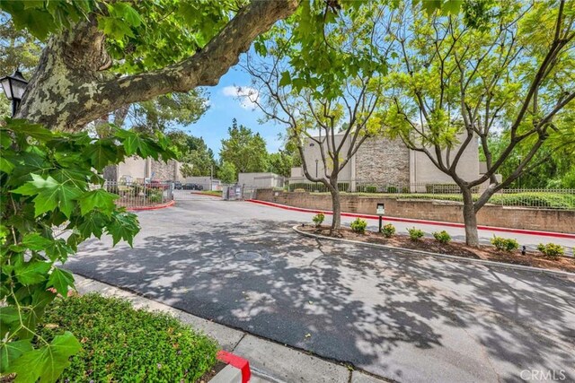 3062 Associated Rd Unit 9, Fullerton, CA 92835 - view of asphalt road with curbs and a gated entry