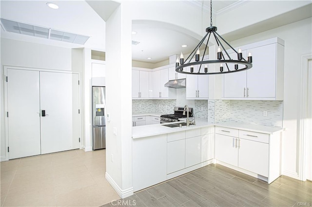 1598 Long Bch Unit 405, Long Beach, CA 90813 - kitchen featuring under cabinet range hood, appliances with stainless steel finishes, light countertops, ornamental molding, and white cabinetry