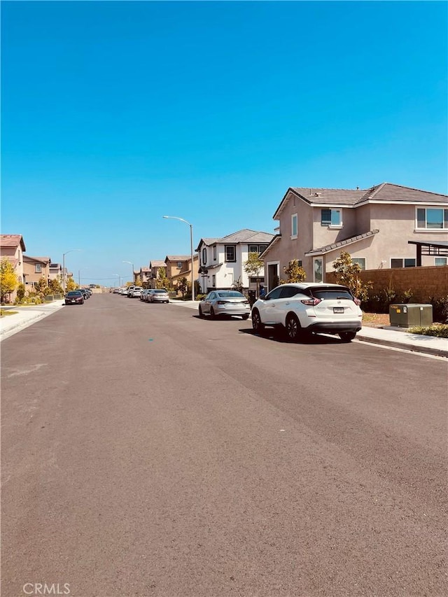 2518 Gunner Rdg, Rialto, CA 92377 - view of asphalt road featuring a residential view, sidewalks, street lighting, and curbs