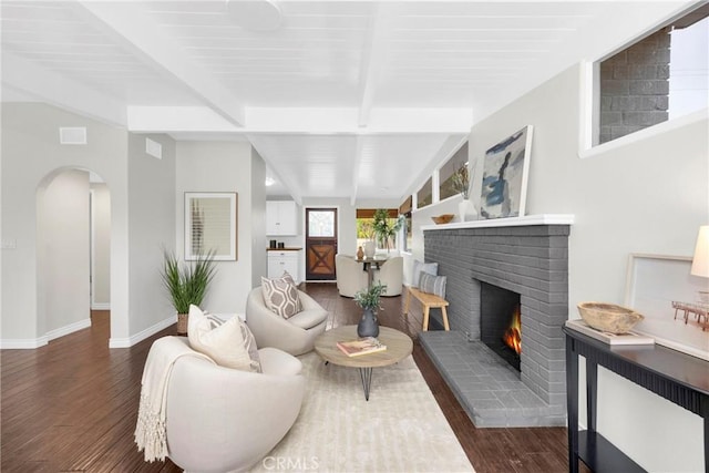 9 W Avenida Cornelio, San Clemente, CA 92672 - living area featuring a brick fireplace, arched walkways, beamed ceiling, wood finished floors, and baseboards