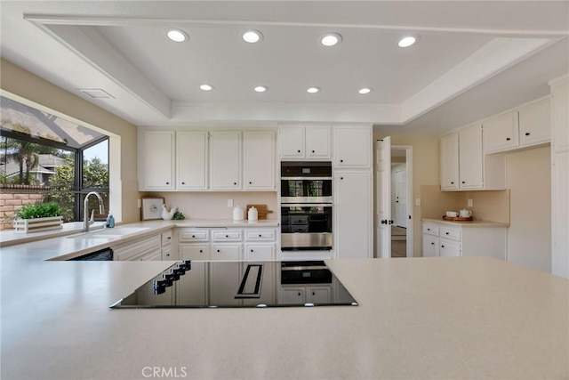 5697 Los Robles, La Verne, CA 91750 - kitchen featuring a sink, double oven, black electric cooktop, light countertops, and white cabinetry