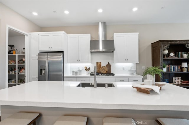 27227 Coyote Bush Ct, Valencia, CA 91381 - kitchen featuring stainless steel refrigerator with ice dispenser, wall chimney range hood, a kitchen breakfast bar, backsplash, and light countertops