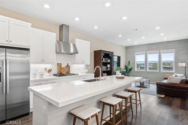 27227 Coyote Bush Ct, Valencia, CA 91381 - kitchen with stainless steel appliances, a sink, wall chimney exhaust hood, open floor plan, and dark wood-style floors