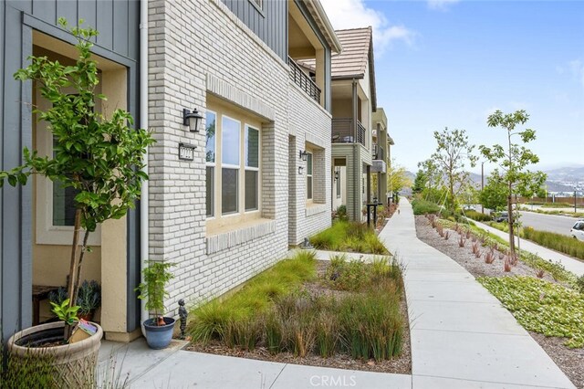 27227 Coyote Bush Ct, Valencia, CA 91381 - view of property exterior with brick siding, board and batten siding, and a balcony