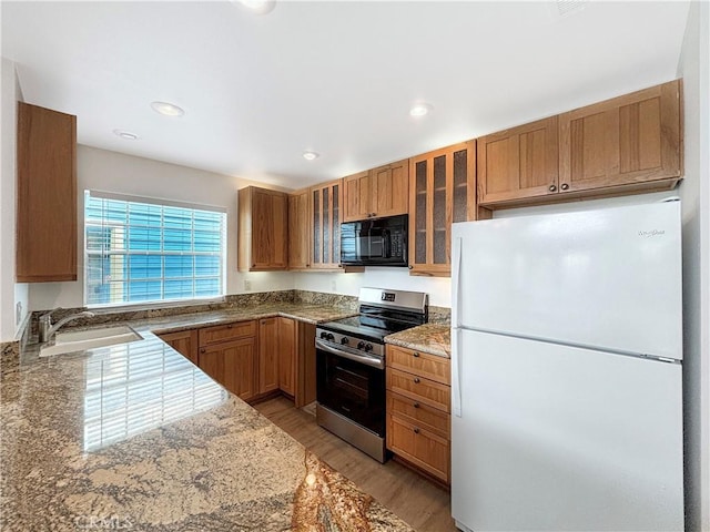 801 Nantasket Ct Unit B, San Diego, CA 92109 - kitchen featuring freestanding refrigerator, electric stove, black microwave, light wood-style flooring, and glass insert cabinets
