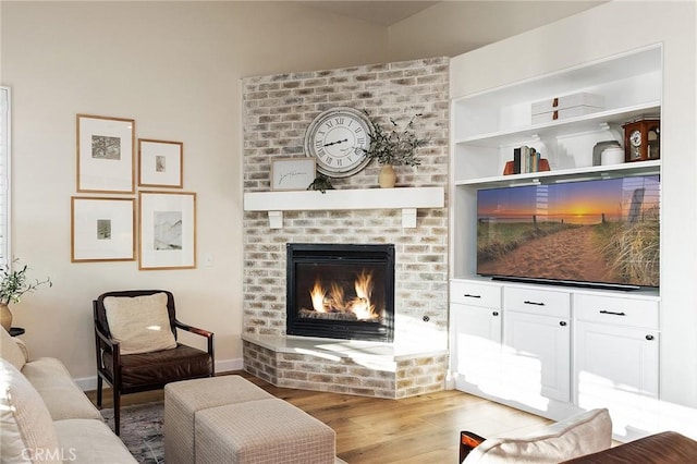 7476 Sequoia Ln, Highland, CA 92346 - living room with light wood-type flooring, a brick fireplace, and baseboards