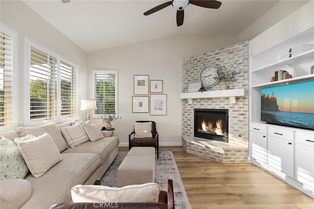 7476 Sequoia Ln, Highland, CA 92346 - living area with vaulted ceiling, light wood-style flooring, a ceiling fan, and a fireplace
