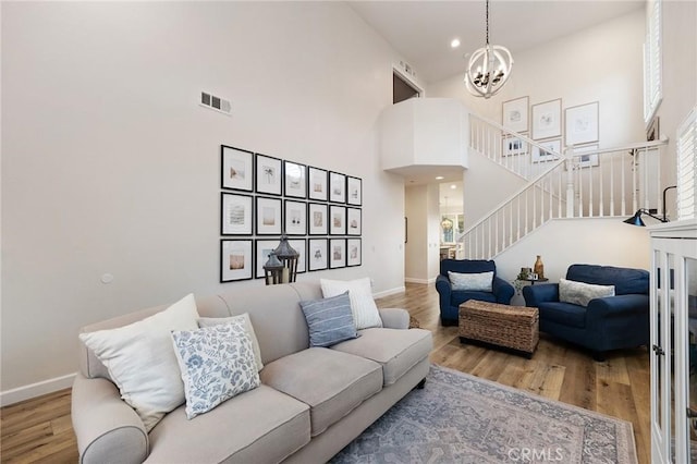 7476 Sequoia Ln, Highland, CA 92346 - living room with a high ceiling, a chandelier, wood finished floors, stairway, and baseboards