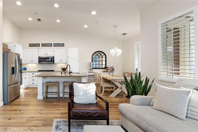 7476 Sequoia Ln, Highland, CA 92346 - living area featuring a chandelier, vaulted ceiling, light wood-style flooring, and recessed lighting
