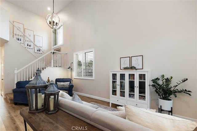 7476 Sequoia Ln, Highland, CA 92346 - living room featuring a towering ceiling, stairway, wood finished floors, a chandelier, and baseboards