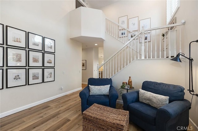 7476 Sequoia Ln, Highland, CA 92346 - sitting room featuring a towering ceiling, wood finished floors, baseboards, and stairway