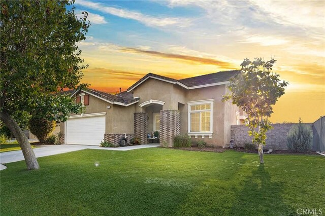 7476 Sequoia Ln, Highland, CA 92346 - view of front of house featuring stucco siding, a yard, driveway, and an attached garage
