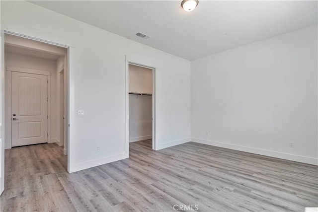 1734 Lester Ave, Clovis, CA 93619 - unfurnished bedroom with light wood-style flooring, baseboards, a closet, and a walk in closet