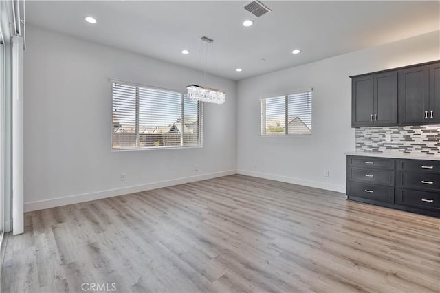 1734 Lester Ave, Clovis, CA 93619 - unfurnished living room with light wood-style floors, baseboards, recessed lighting, and a chandelier