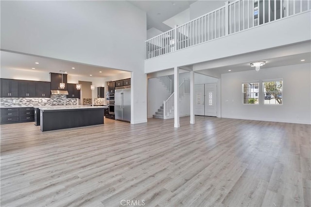 1734 Lester Ave, Clovis, CA 93619 - unfurnished living room featuring stairs, light wood finished floors, a high ceiling, and recessed lighting