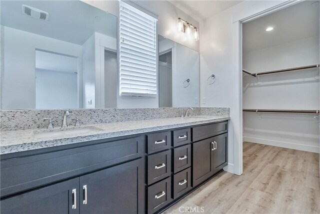 1734 Lester Ave, Clovis, CA 93619 - full bathroom featuring double vanity, wood finished floors, baseboards, and a walk in closet