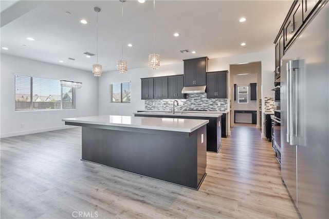 1734 Lester Ave, Clovis, CA 93619 - kitchen with a large island with sink, appliances with stainless steel finishes, light countertops, a sink, and backsplash