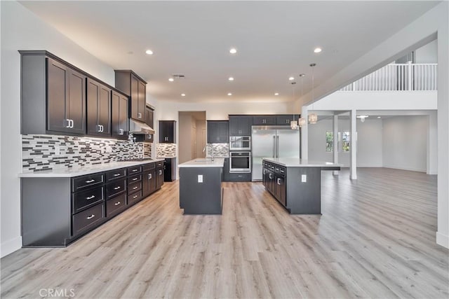 1734 Lester Ave, Clovis, CA 93619 - kitchen featuring an island with sink, a sink, appliances with stainless steel finishes, light countertops, and backsplash
