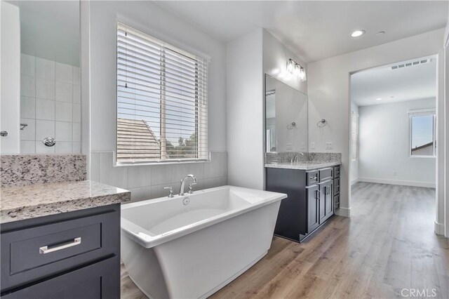 1734 Lester Ave, Clovis, CA 93619 - full bathroom featuring wood finished floors, a soaking tub, vanity, and recessed lighting