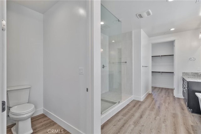 1734 Lester Ave, Clovis, CA 93619 - full bathroom with tiled shower, vanity, a walk in closet, toilet, and wood finished floors