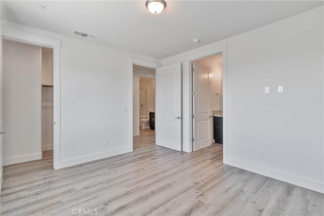 1734 Lester Ave, Clovis, CA 93619 - unfurnished bedroom with light wood-style floors, baseboards, a walk in closet, and ensuite bathroom