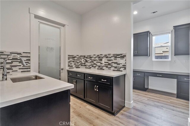 1734 Lester Ave, Clovis, CA 93619 - kitchen with a sink, light countertops, tasteful backsplash, light wood-style floors, and recessed lighting