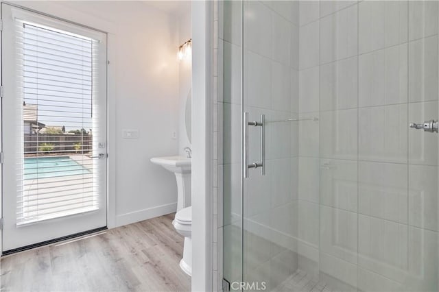 1734 Lester Ave, Clovis, CA 93619 - bathroom with toilet, a stall shower, wood finished floors, and baseboards