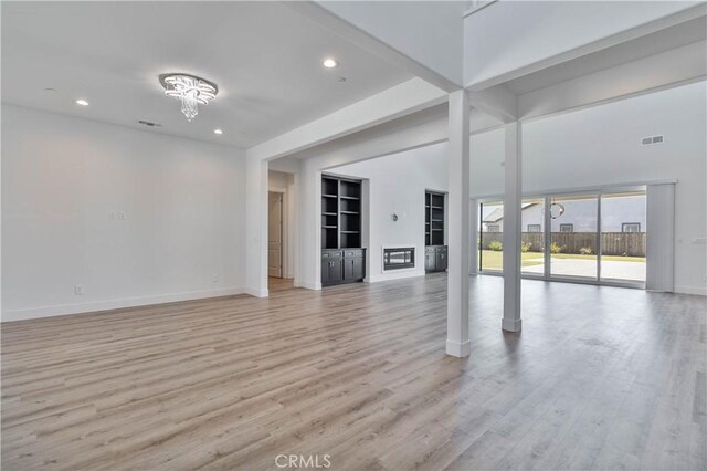 1734 Lester Ave, Clovis, CA 93619 - unfurnished living room with baseboards, light wood-type flooring, recessed lighting, built in features, and a glass covered fireplace