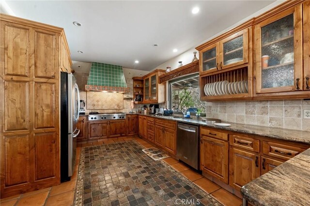 9075 Mesa Vista St, Apple Valley, CA 92308 - kitchen featuring appliances with stainless steel finishes, brown cabinetry, backsplash, dark stone counters, and recessed lighting
