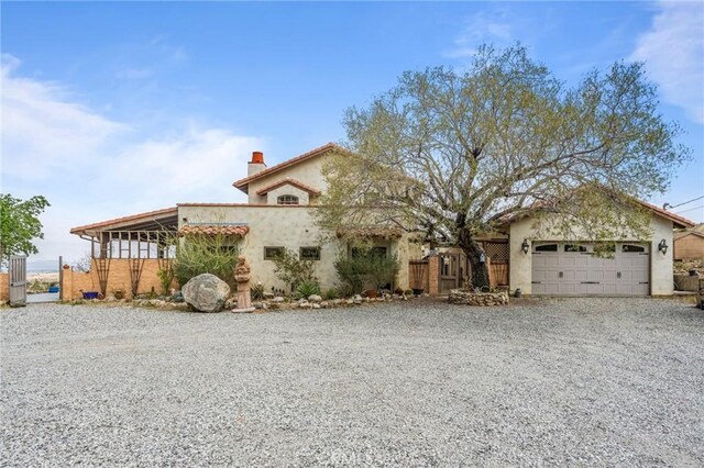 9075 Mesa Vista St, Apple Valley, CA 92308 - mediterranean / spanish house featuring driveway, a garage, stucco siding, and a chimney