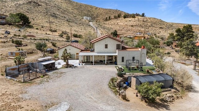 9075 Mesa Vista St, Apple Valley, CA 92308 - back of property with an outdoor structure, a mountain view, stucco siding, and view of desert landscape