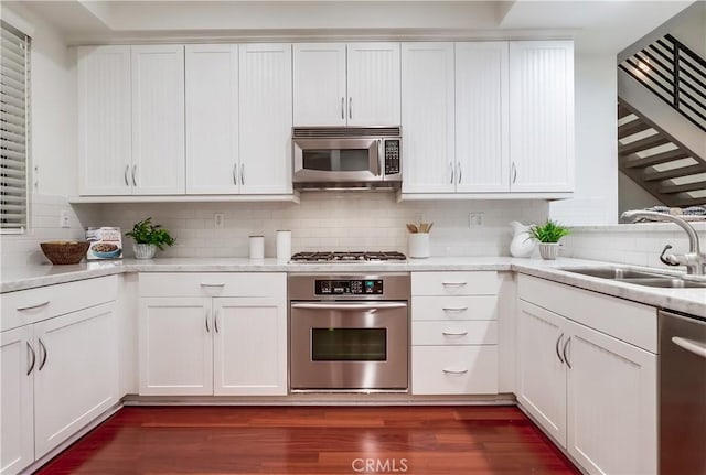 395 E 4th St Unit 13, Long Beach, CA 90802 - kitchen featuring stainless steel appliances, a sink, backsplash, and dark wood-style floors
