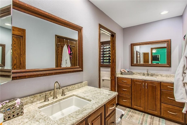 639 Valley View Dr, Redlands, CA 92373 - full bathroom with two vanities, toilet, and recessed lighting