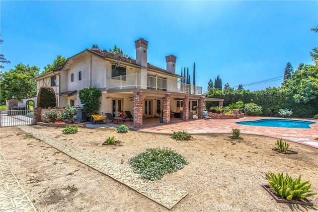 639 Valley View Dr, Redlands, CA 92373 - back of property with a balcony, french doors, a chimney, and a patio