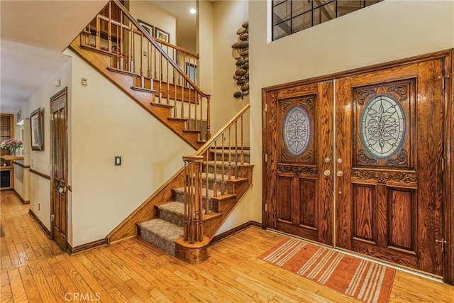 639 Valley View Dr, Redlands, CA 92373 - entryway with wood-type flooring, stairs, baseboards, and a towering ceiling