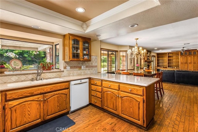 639 Valley View Dr, Redlands, CA 92373 - kitchen with white dishwasher, a sink, a peninsula, light wood-style floors, and brown cabinetry