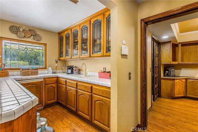 639 Valley View Dr, Redlands, CA 92373 - kitchen with a sink, light wood-type flooring, glass insert cabinets, and tile countertops