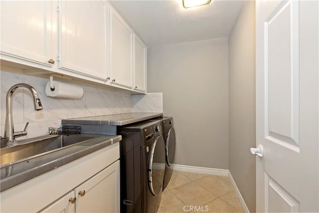 7000 Fabriano Pl, Rancho Cucamonga, CA 91701 - laundry area featuring cabinet space, washing machine and dryer, light tile patterned floors, and baseboards