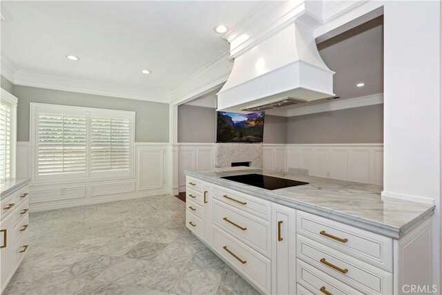 7000 Fabriano Pl, Rancho Cucamonga, CA 91701 - kitchen featuring black electric cooktop, a decorative wall, premium range hood, wainscoting, and light stone countertops
