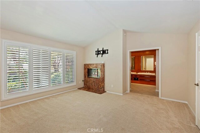 7000 Fabriano Pl, Rancho Cucamonga, CA 91701 - unfurnished living room featuring carpet flooring, a premium fireplace, baseboards, and lofted ceiling