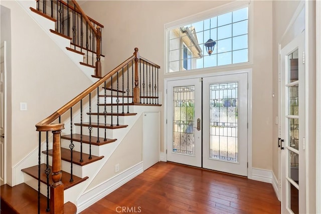 7000 Fabriano Pl, Rancho Cucamonga, CA 91701 - entryway with french doors, wood-type flooring, stairway, a towering ceiling, and baseboards
