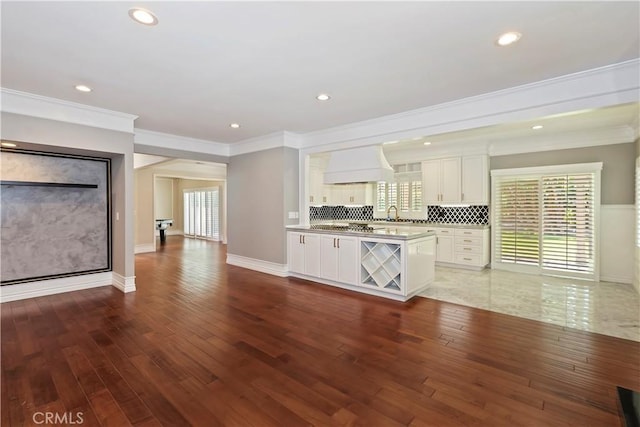 7000 Fabriano Pl, Rancho Cucamonga, CA 91701 - kitchen with premium range hood, white cabinetry, ornamental molding, wood finished floors, and recessed lighting