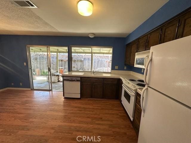 869 El Portal Dr, Merced, CA 95340 - kitchen featuring white appliances, wood finished floors, a sink, and light countertops