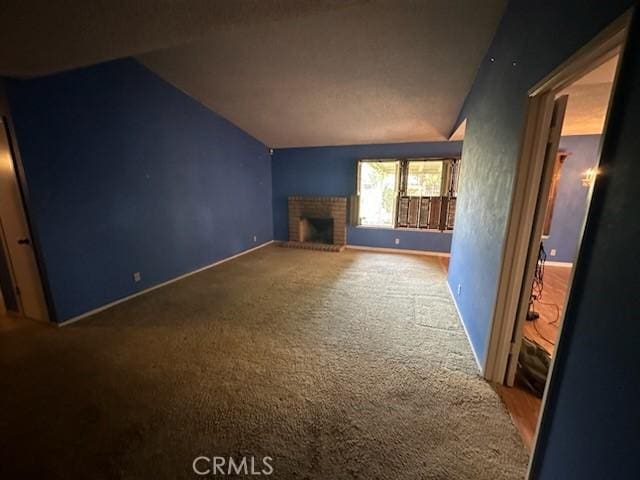 869 El Portal Dr, Merced, CA 95340 - unfurnished living room with lofted ceiling, a fireplace, carpet floors, and baseboards