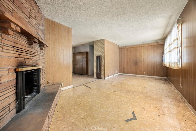 5426 Lakeview Ave, Yorba Linda, CA 92886 - unfurnished living room with a large fireplace, a textured ceiling, baseboards, and wood walls