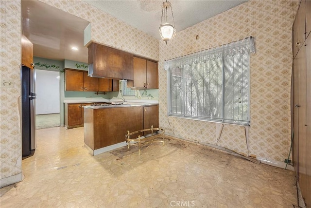 5426 Lakeview Ave, Yorba Linda, CA 92886 - kitchen with wallpapered walls, brown cabinets, freestanding refrigerator, a peninsula, and light flooring