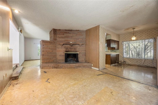 5426 Lakeview Ave, Yorba Linda, CA 92886 - unfurnished living room with a textured ceiling, baseboards, and a stone fireplace