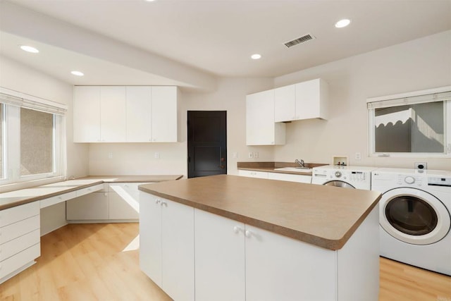 1320 Sleeping Indian Rd, Oceanside, CA 92057 - laundry area with washing machine and dryer, light wood-style flooring, recessed lighting, and cabinet space