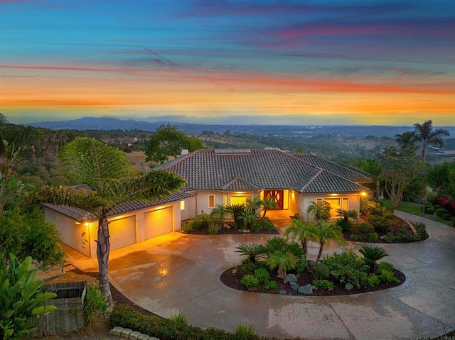 1320 Sleeping Indian Rd, Oceanside, CA 92057 - view of front facade with a tile roof, an attached garage, curved driveway, and stucco siding