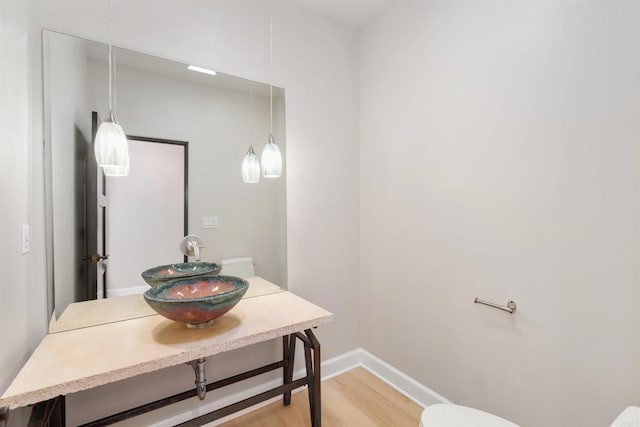 1320 Sleeping Indian Rd, Oceanside, CA 92057 - half bathroom with toilet, wood finished floors, and baseboards